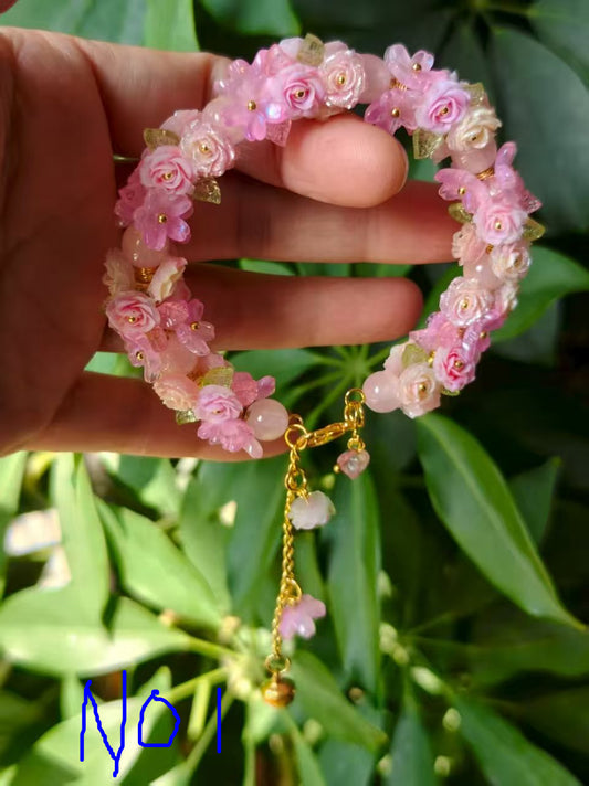 HandMadeBracelet-This pink flower sea bracelet features delicate resin flowers;